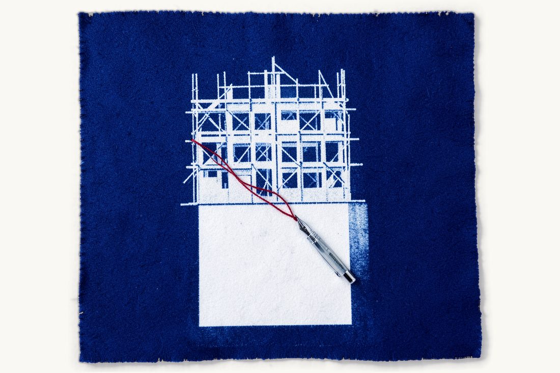 Construction contracts in Türkiye, the eser sözleşmesi: a building under construction with scaffolding, a blank sheet with a fountain pen, joined by a red thread, cyanotype print