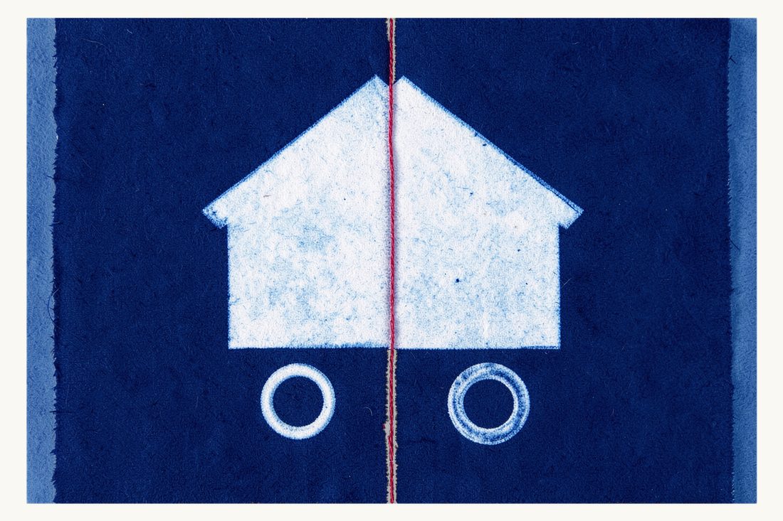 Property division in a Turkish divorce: a house cut cleanly in half with its two halves pulled apart, a vertical red thread in the gap, two wedding rings below, cyanotype print