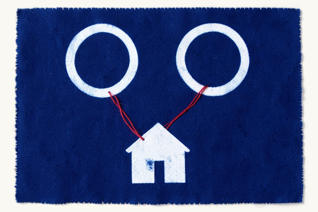 Financial claims between divorcing spouses in Turkey: two large wedding rings set apart, a red thread running from both rings around a small house below, cyanotype print